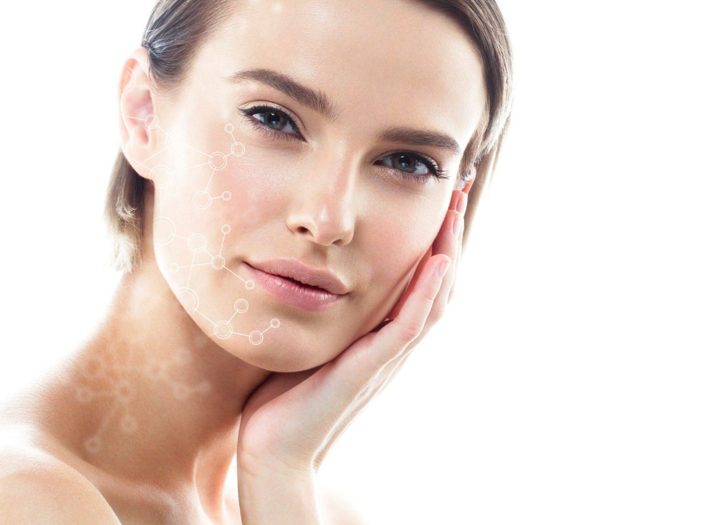 A woman with clear skin gently touching her face with one hand, looking directly at the camera. A subtle overlay of molecular structures is superimposed on her cheek, suggesting a focus on skincare or beauty technology. The background is white and minimalistic.