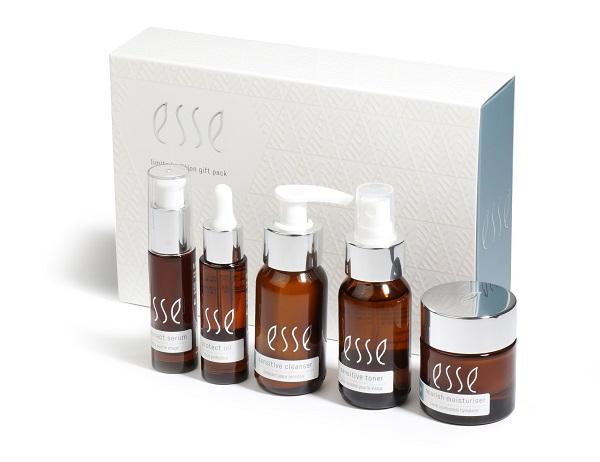 A skincare gift pack featuring five items in brown bottles with white labels that read "esse." The set includes a serum, an extract oil, a gentle cleanser, a sensitive toner, and a rich moisturizer, all placed in front of a white patterned box with the "esse" logo.