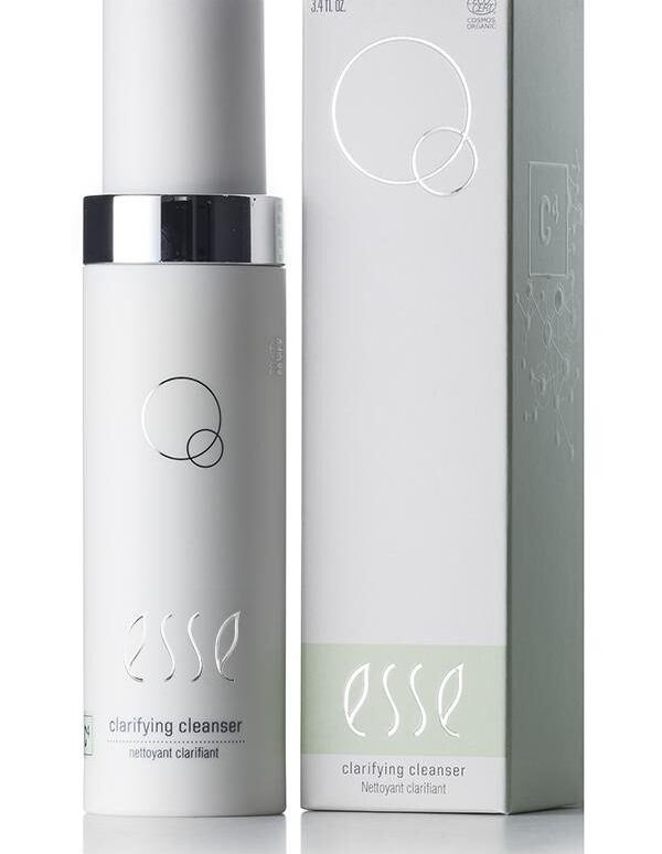 An image of the Esse Clarifying Cleanser, a skincare product in a sleek white bottle with a silver cap, is presented alongside its matching white and light green packaging box. Both the bottle and box showcase simple, minimalist design elements.