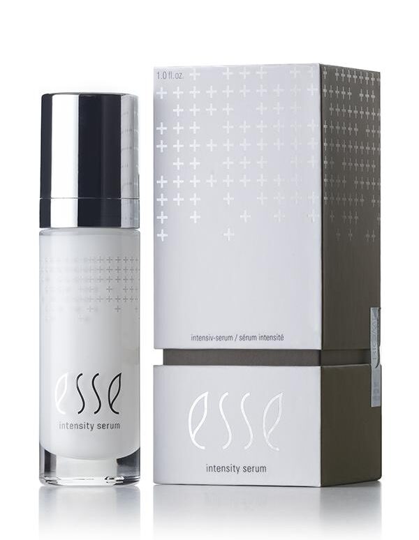 A sleek bottle of Esse Intensity Serum stands next to its matching box. The bottle is pristine white, adorned with a black cap and subtle silver accents, while the box features a clean white and gray palette with an elegant minimalist design. The product name, "Esse Intensity Serum," is prominently displayed on both items.